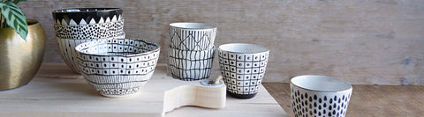 Patterned black and white tumblers displayed on wood board